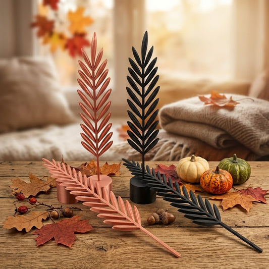 Schwarze und kupferfarbene Deko-Federn auf Sockeln und liegend in einer Herbstszene.